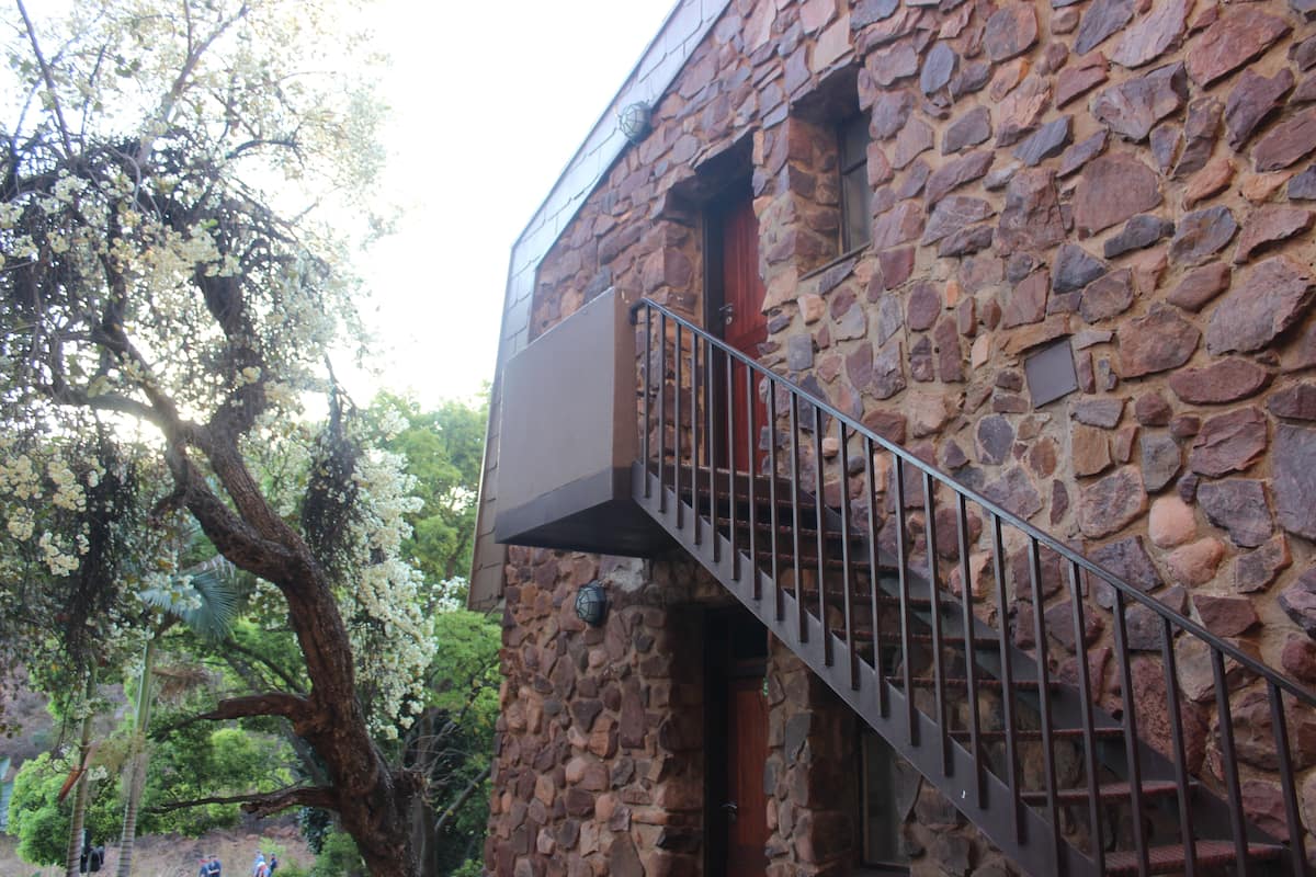 A stone building with a metal staircase leading to an upper level.