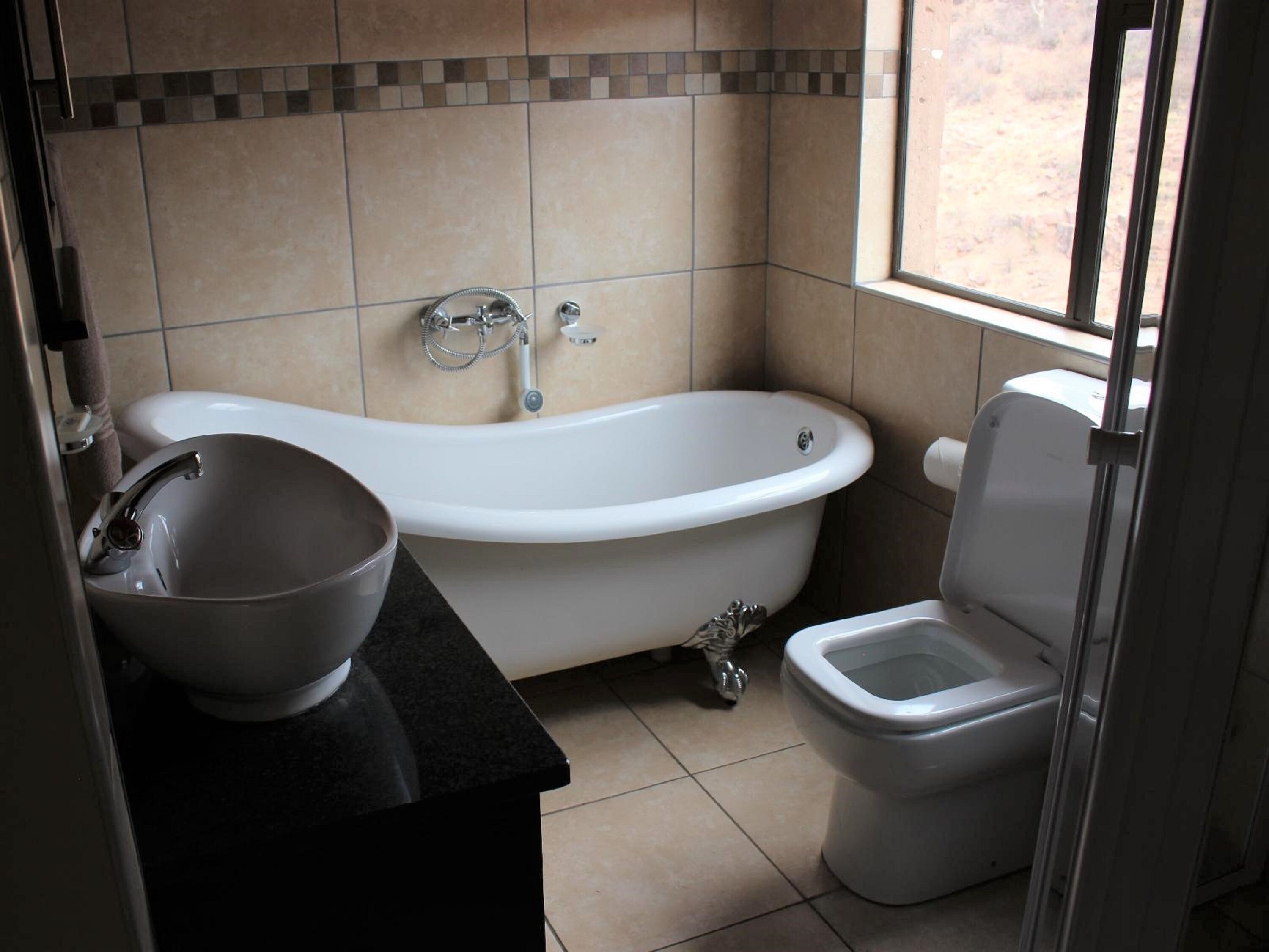 A bathroom with a freestanding bathtub, a sink, and a toilet.
