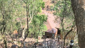 Uma escadaria de pedra com grades de metal que leva a um edifício com telhado vermelho.