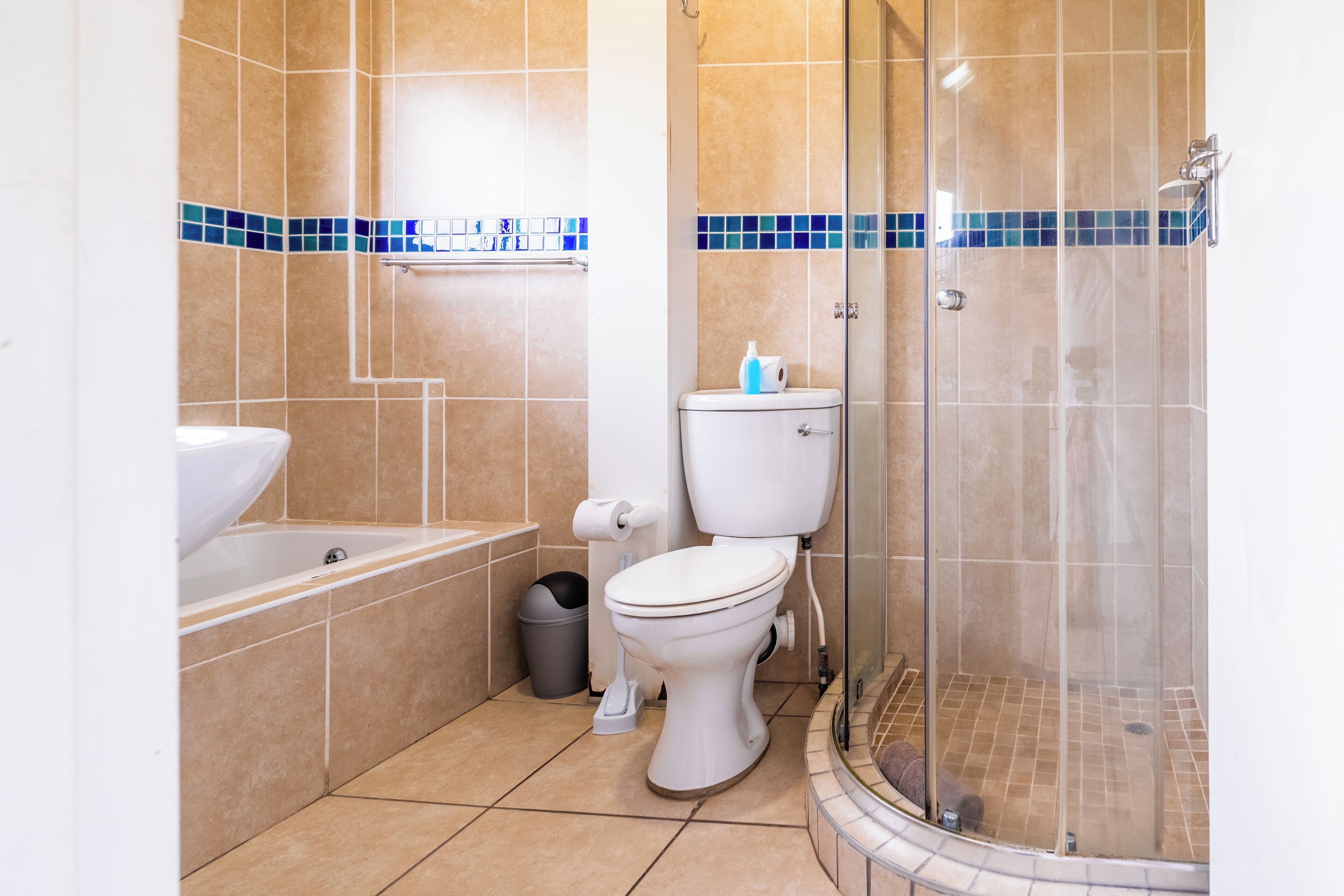 A bathroom with a toilet, a sink, a bathtub, and a glass-enclosed shower.
