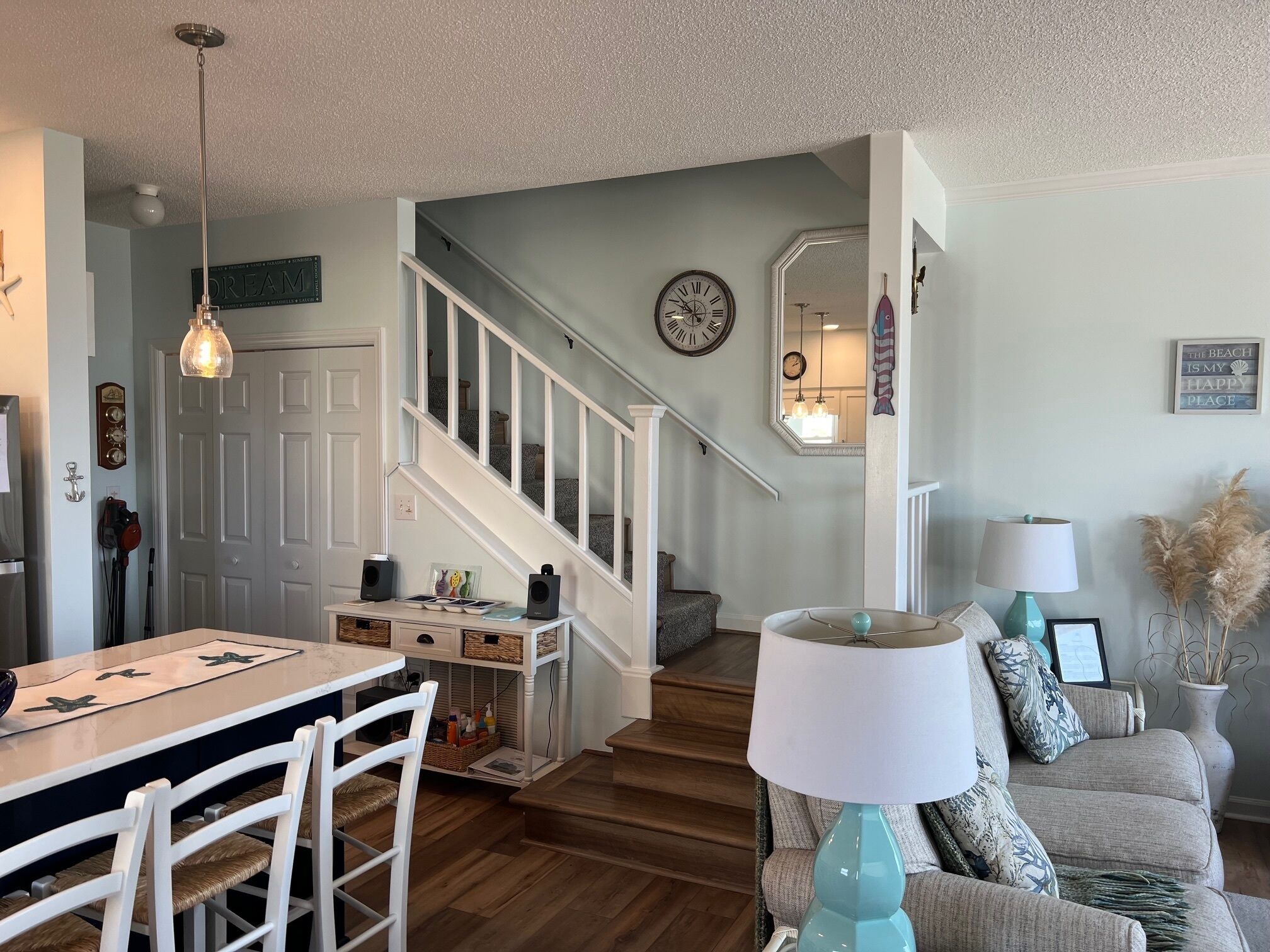 A living room with a dining area, a staircase, and a view of the upper floor.