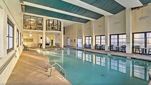An indoor swimming pool with clear water, surrounded by windows and seating areas. - Lifes a beach on Myrtle Beach (Myrtle Beach)