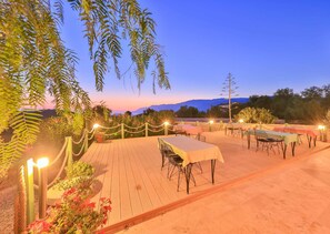 An outdoor dining area with tables and chairs, surrounded by plants and a view of the mountains. - Lacitrus Villa Hotel (Kas)