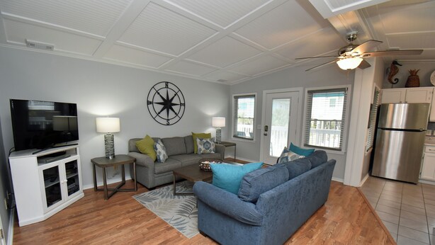 A living room with a television, sofa, and a ceiling fan. - Sunset Square N - Second Row Complex in Garden City Beach (Garden City)
