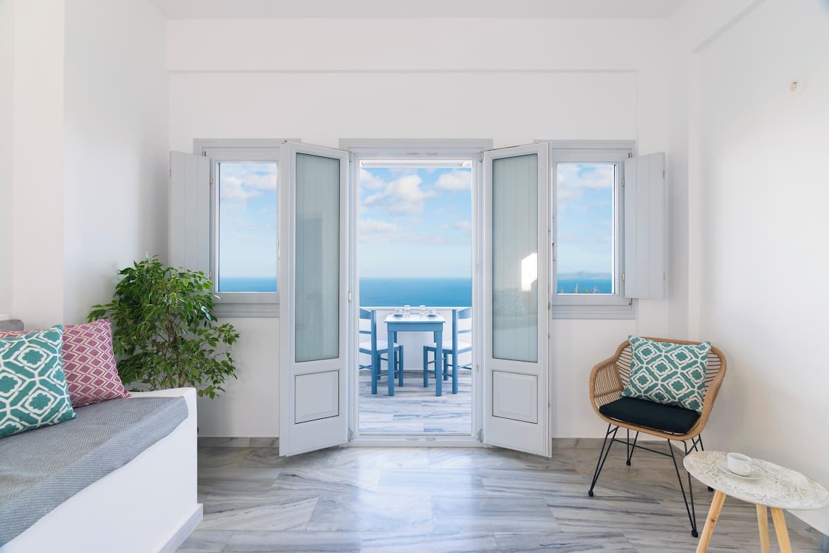 Ein Zimmer mit Meerblick, einem Esstisch, einem Sessel und einer Couch.