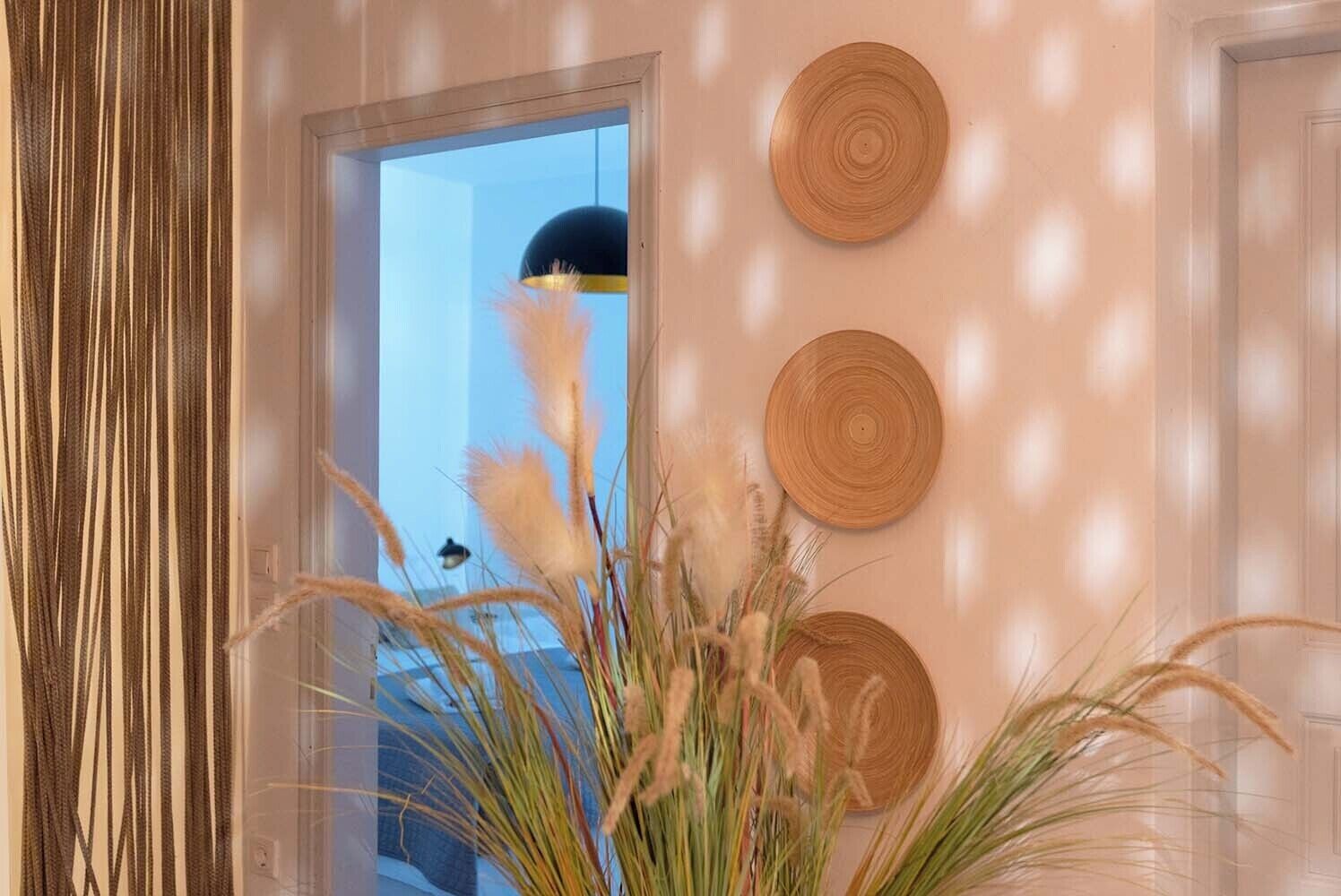 A room with a door, a window, and three woven wall decorations.
