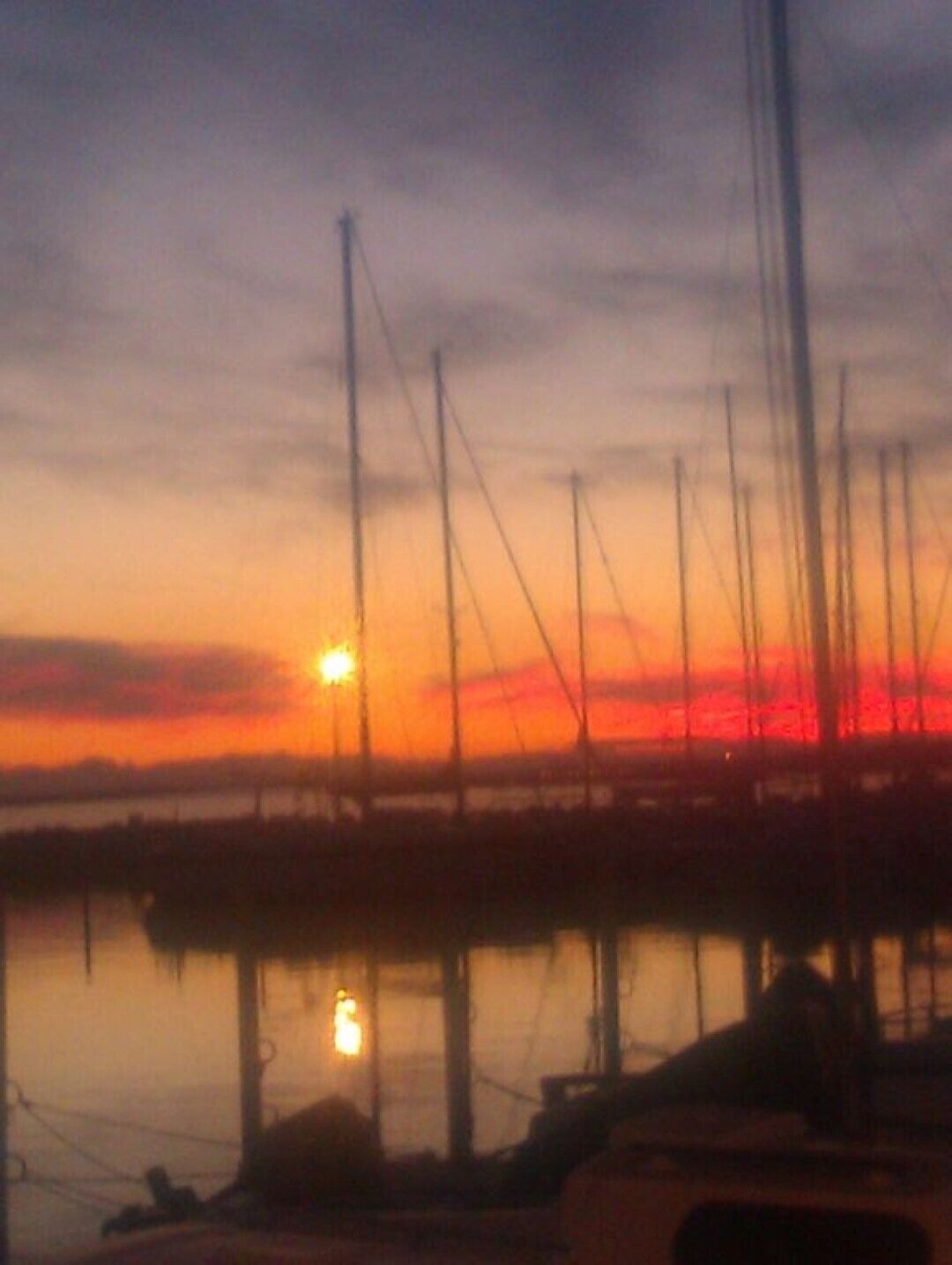 A sunset over a marina with boats docked.
