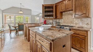 A spacious kitchen with granite countertops, wooden cabinets, and a large island. - Beautiful Home, spacious office & Xbox Game Room. (Montgomery County)