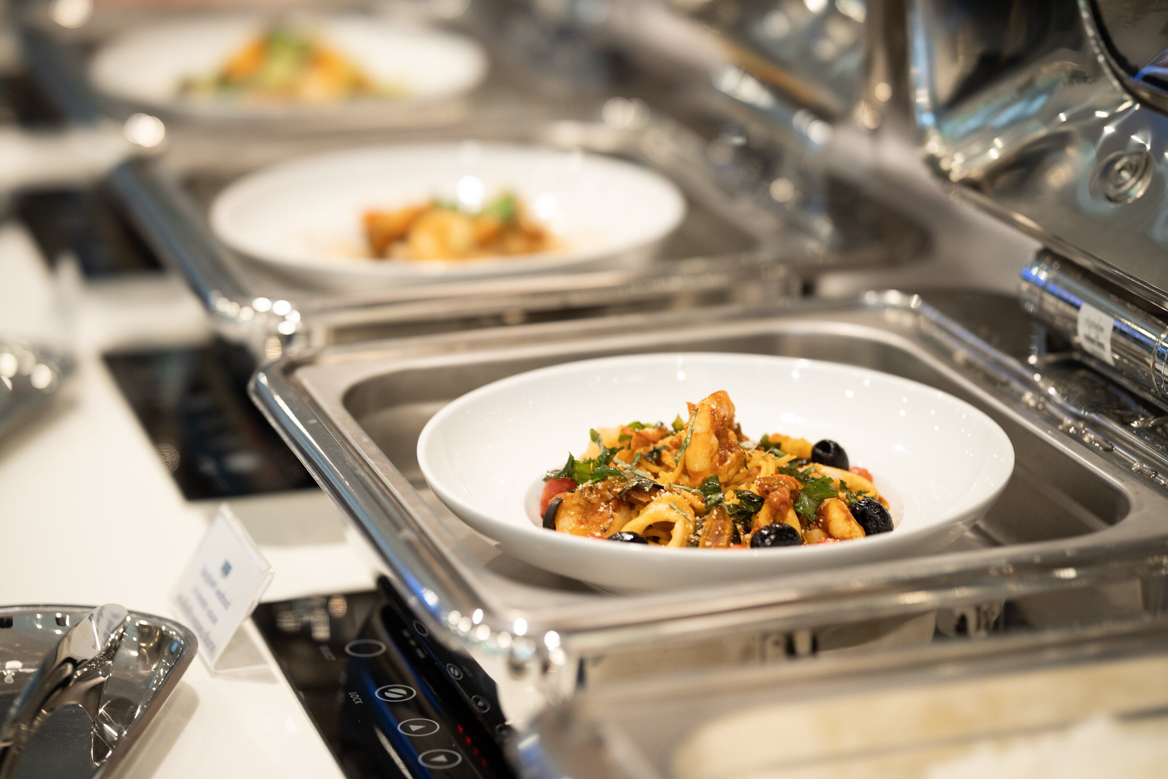 Un buffet proposant différents plats de pâtes, présentés dans de nombreux plats.