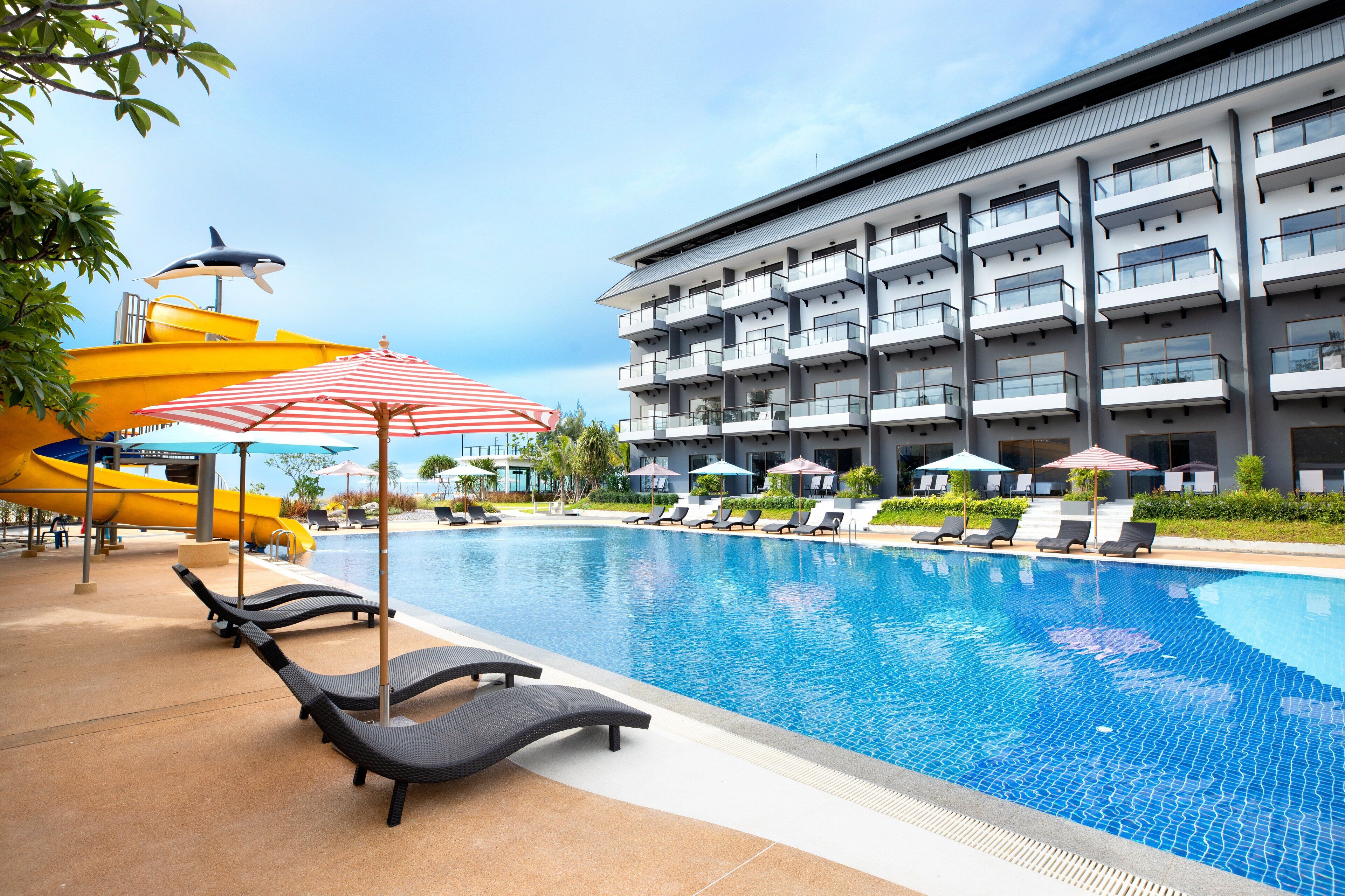 Una piscina al aire libre, sillones reclinables de piscina