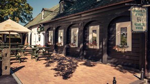 A wooden building with arched windows and outdoor seating. - Hotel Dymník (Rumburk)