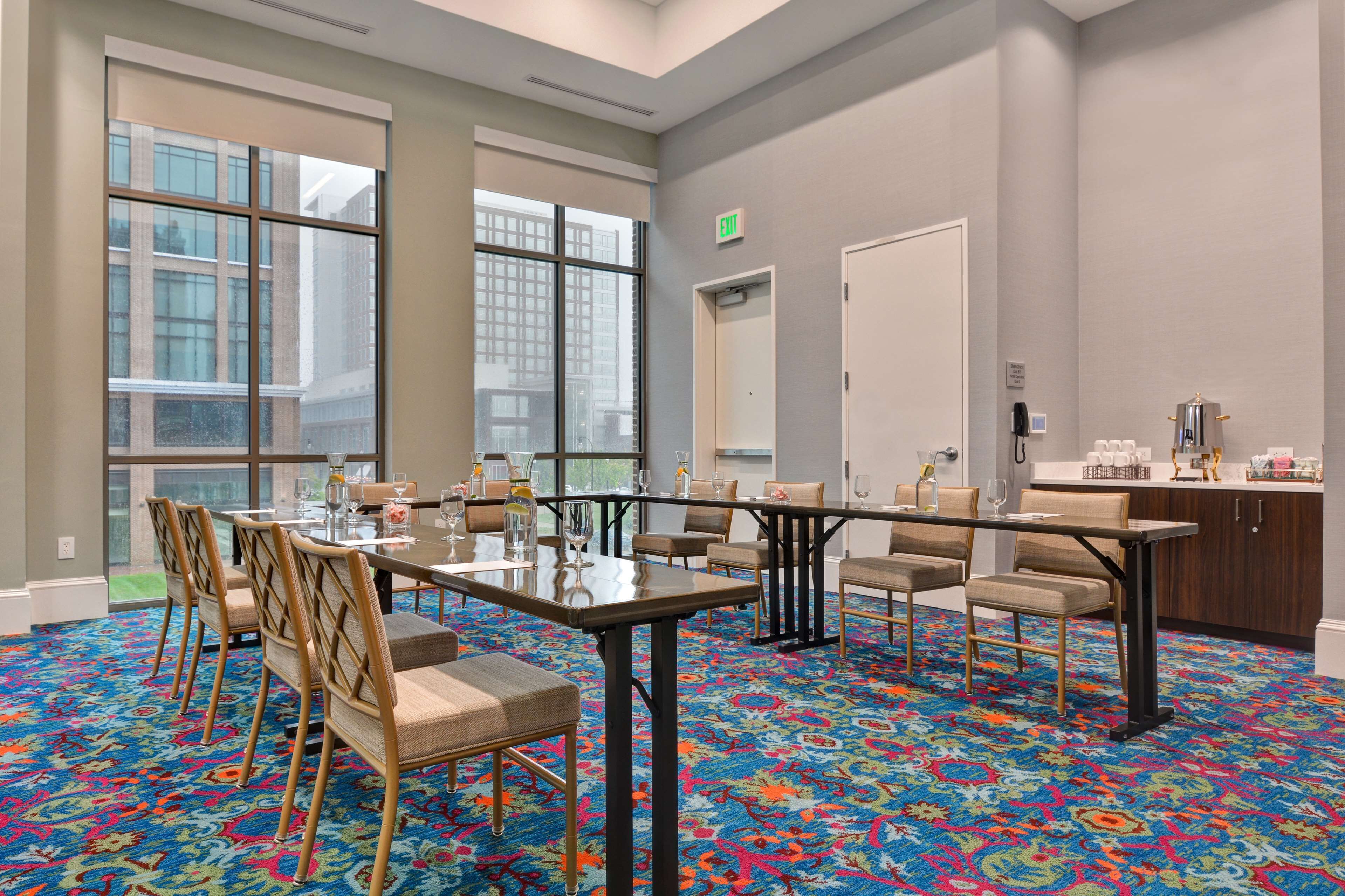 A conference room with a large table, chairs, and a carpeted floor.