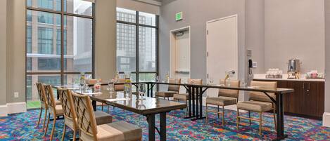A conference room with a large table, chairs, and a carpeted floor.