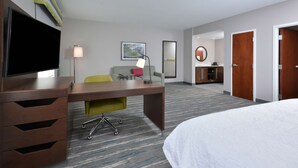 A hotel room with a bed, a desk, a chair, a TV, a lamp, a painting, a mirror, and a wardrobe. - Hampton Inn & Suites by HIlton Charlotte North I 485 (Charlotte)