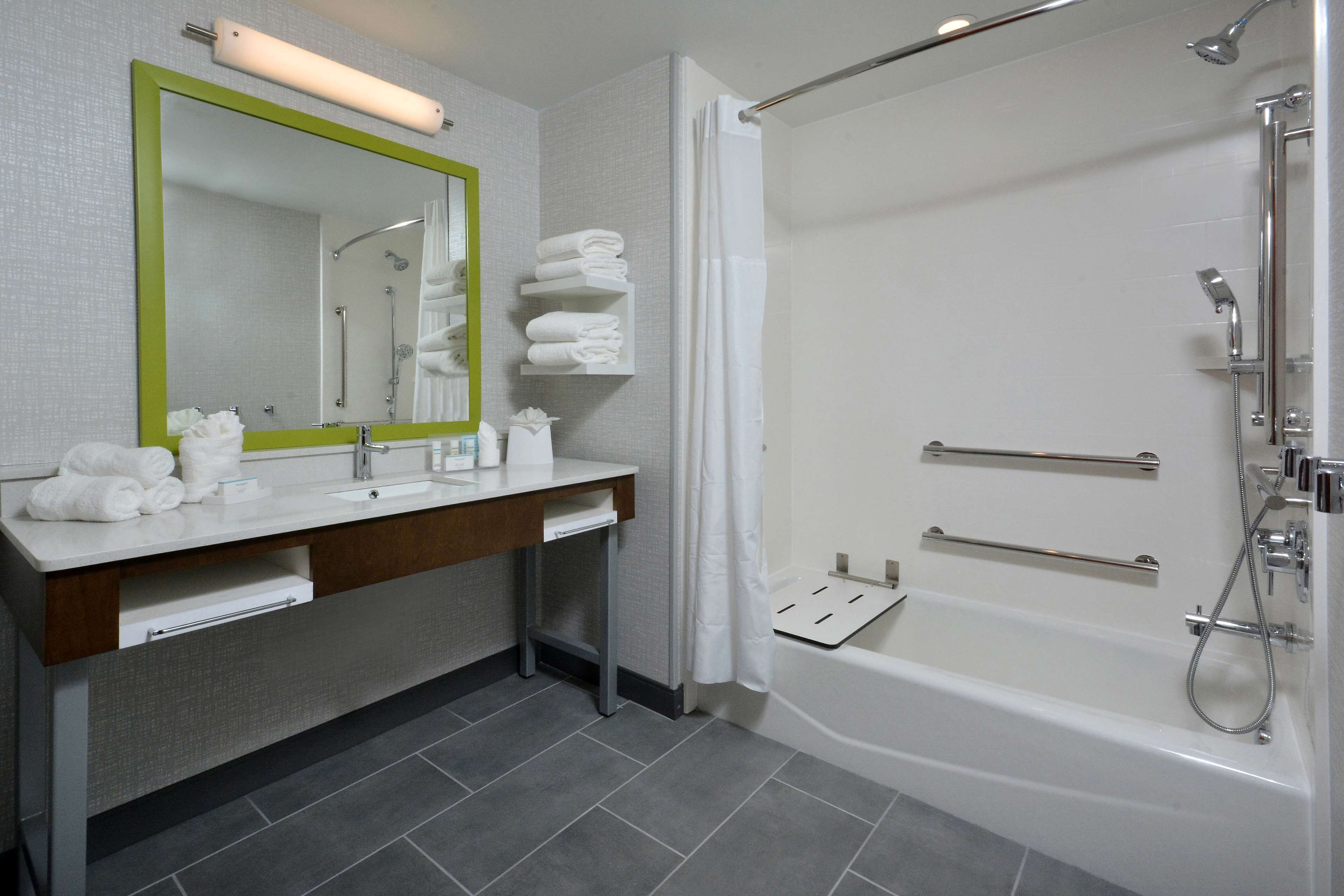 A modern bathroom with a white sink, mirror, and shower.