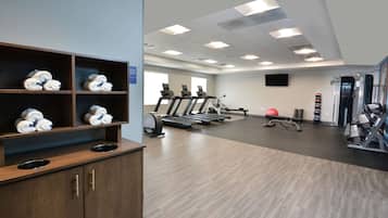 Ein Fitnessraum mit Laufbändern, Rudergerät und einer Wasserspenderstation.
