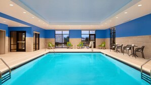 A swimming pool with clear blue water, surrounded by green and black lounge chairs. - Hampton Inn & Suites Franklin Indianapolis (Franklin)