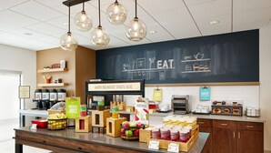 A breakfast bar with various food and drink options, including fruits, juices, and pastries. - Hampton Inn & Suites Franklin Indianapolis (Franklin)