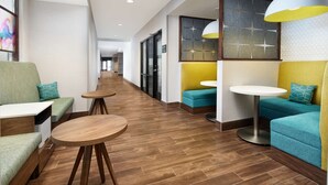 A modern hotel lobby with seating areas, round tables, and pendant lighting. - Hampton Inn & Suites Franklin Indianapolis (Franklin)