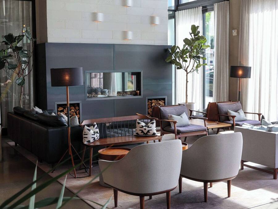 A modern living room with a sofa, armchairs, a coffee table, and a fireplace.