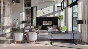 A modern living room with a fireplace, sofas, and a dining table.