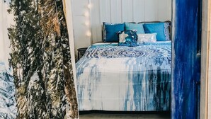 Une chambre à coucher avec un lit, un ventilateur de plafond et des guirlandes lumineuses.