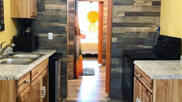 Una cocina estrecha con armarios de madera y una isla central.