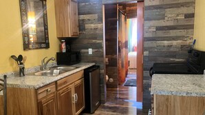 Una cocina con armarios de madera, encimera de granito y lavavajillas.
