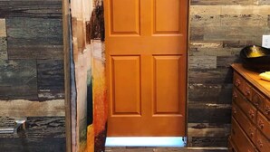 Una puerta de madera con un muro texturizado al fondo.