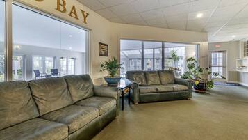 A lobby with leather sofas, large windows, and potted plants.