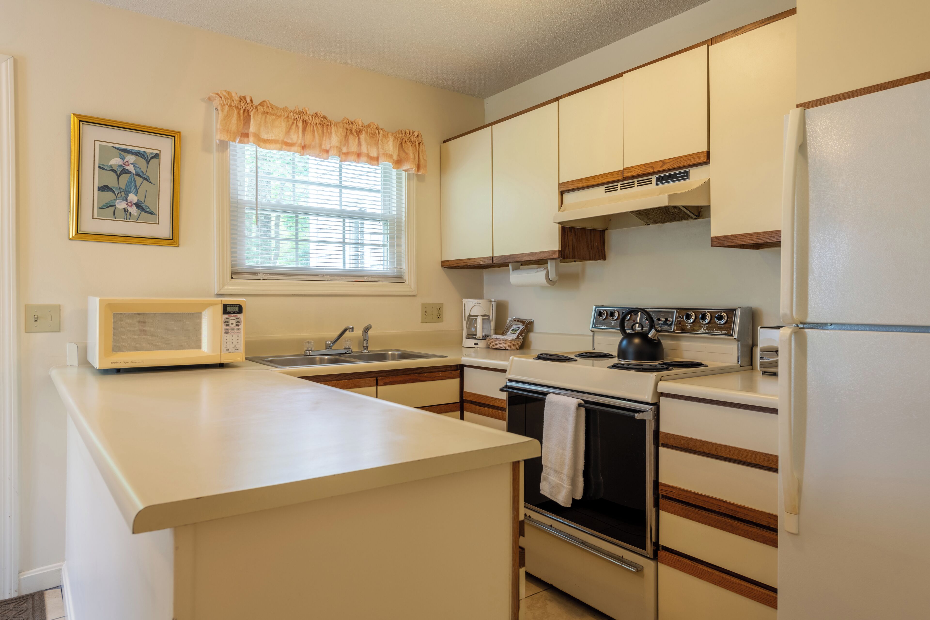 A compact kitchen with a microwave, stove, and refrigerator.