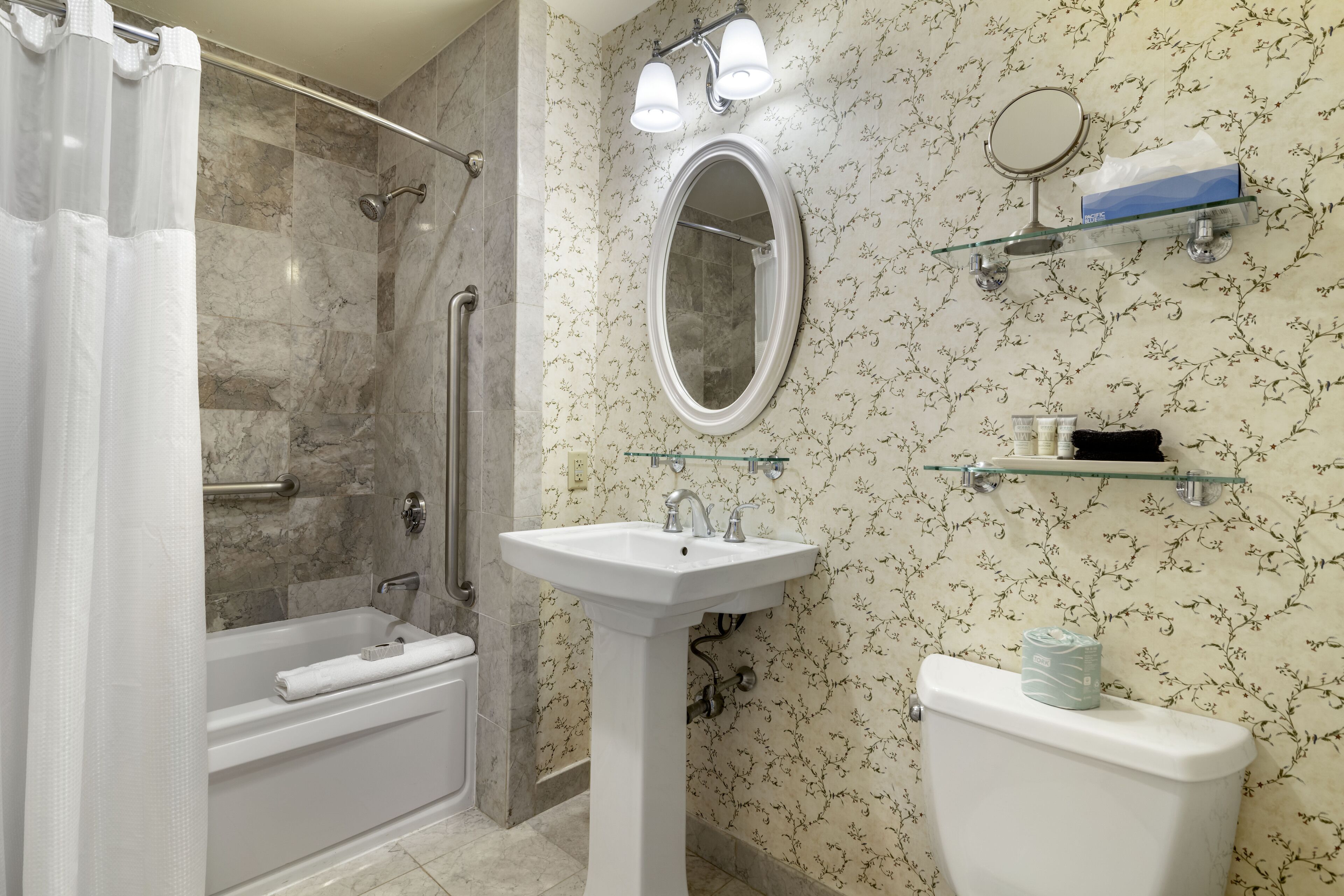 Ein Badezimmer mit Badewanne, Waschbecken, Toilette, Dusche und Spiegel.