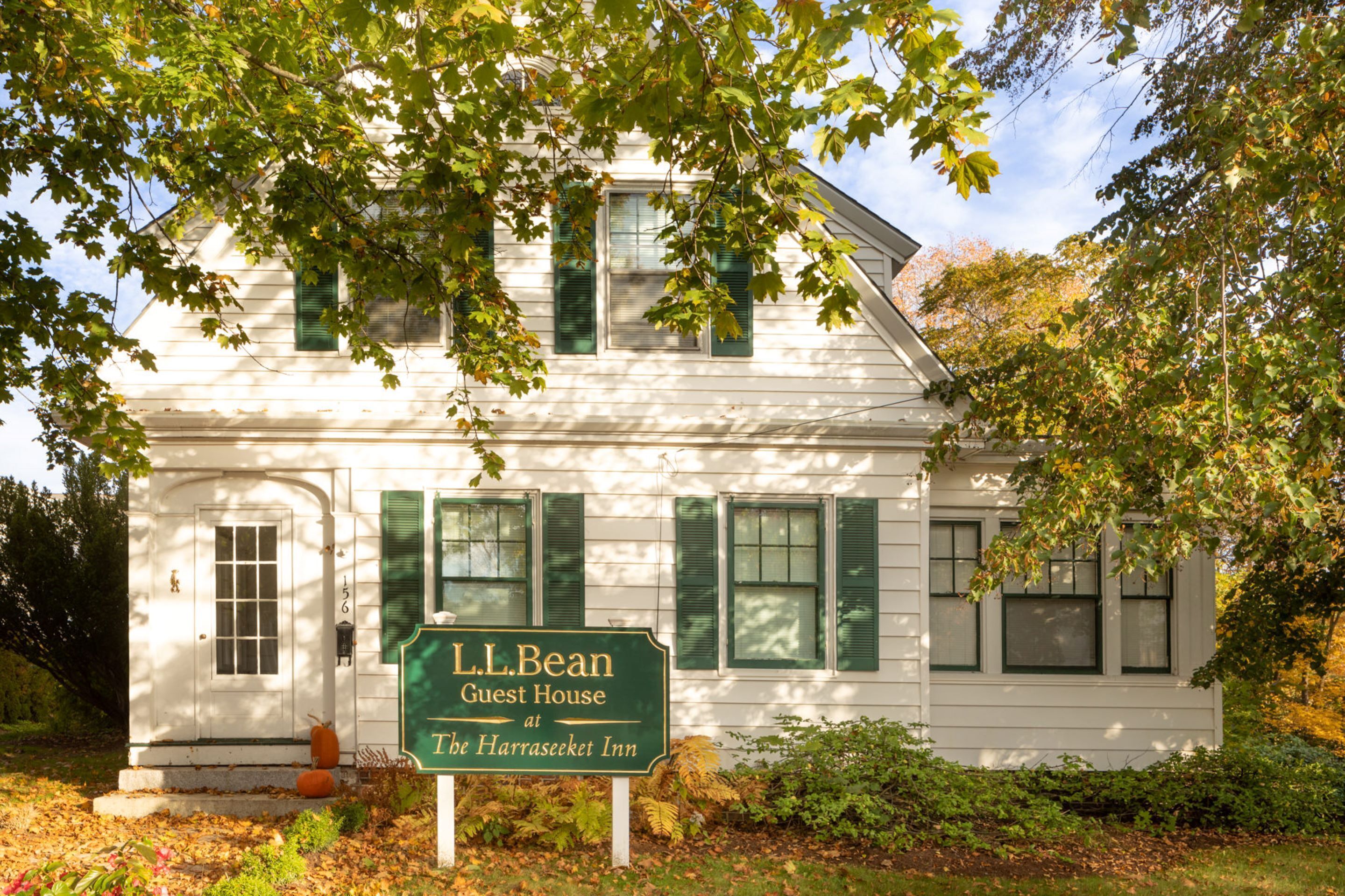 Et hvidt hus med grønne skodder og et skilt, der viser "L.L. Bean Guest House at The Harraseeket Inn".