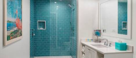 Une salle de bain moderne avec une douche, un lavabo et un grand miroir.