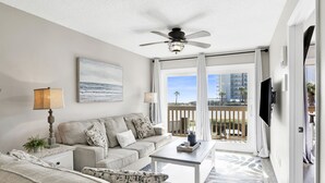 A modern living room with a sofa, coffee table, and a ceiling fan.