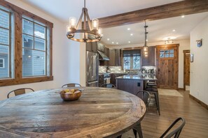 Una cocina amplia con vigas de madera, una isla grande y electrodomésticos modernos.