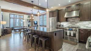 A modern kitchen with a large island, stainless steel appliances, and wooden cabinetry. - Family Retreat w/ Suncadia Pool Access (Cle Elum)