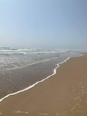 A beach with waves gently lapping onto the shore. - Bahama Breeze #4 (South Padre Island)