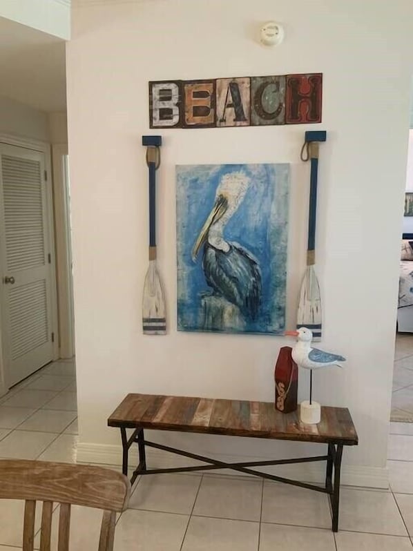 A wall with a painting of a pelican, a wooden table, and a sign that reads "BEACH". - Bahama Breeze #4 (South Padre Island)