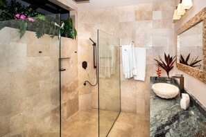 Enjoy a refreshing shower in the bathroom, featuring a glass-enclosed shower, a large sink, and a mirror.