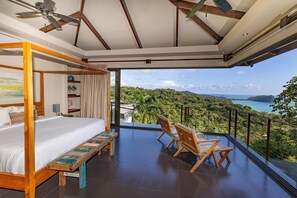 A bedroom with a balcony, a bed, a ceiling fan, and a view of a lush landscape. - Stunning Ocean Views 6BR Villa w/ Private Pool & Sky Suite (Quepos)