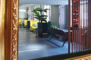 A hotel lobby with yellow seating, a large potted plant, and a modern design. - Shenyang Le Grand V Hotel (Shenyang)