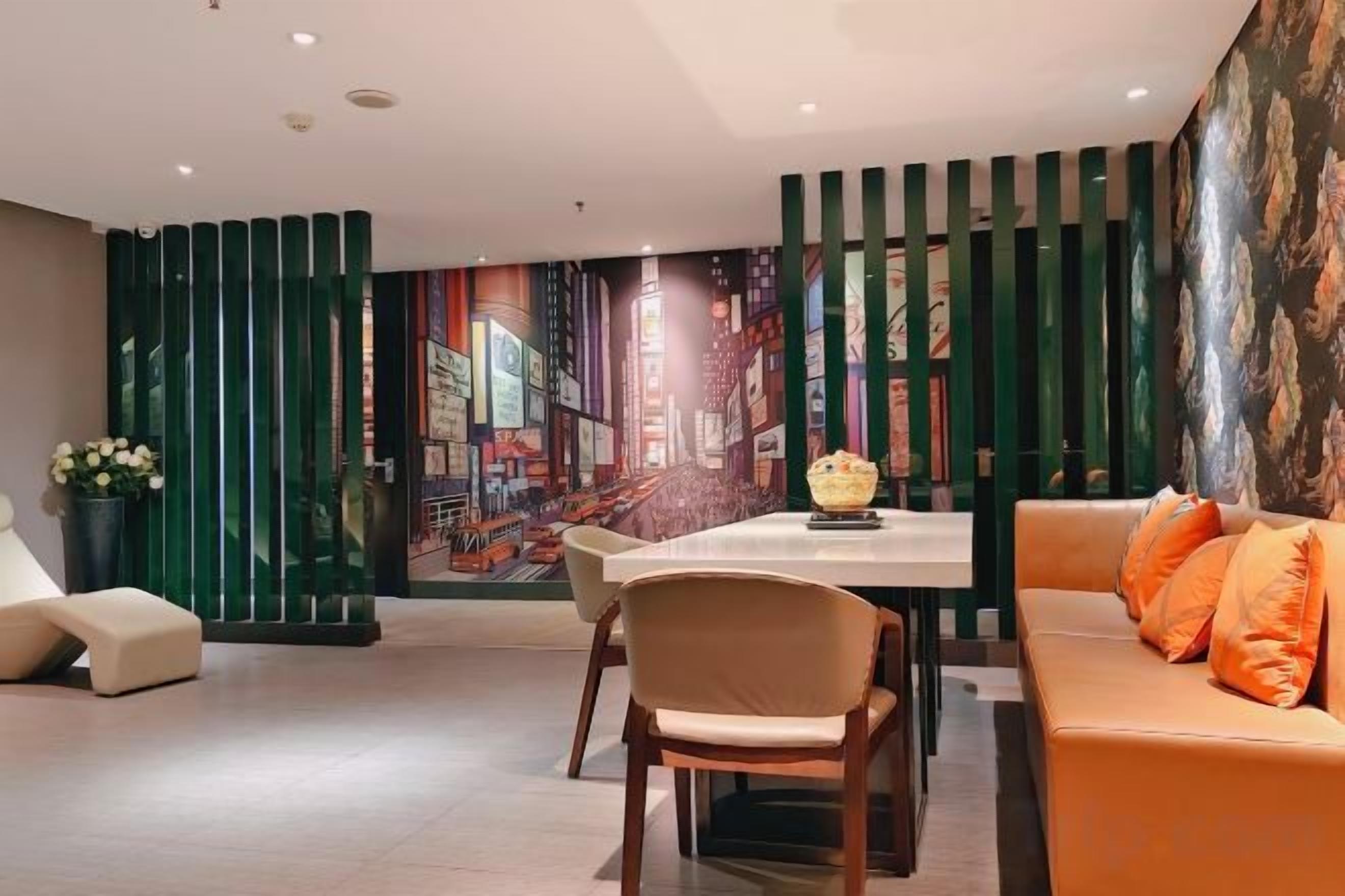 Un interior moderno con zona de comedor, sofá y decoración en la pared.