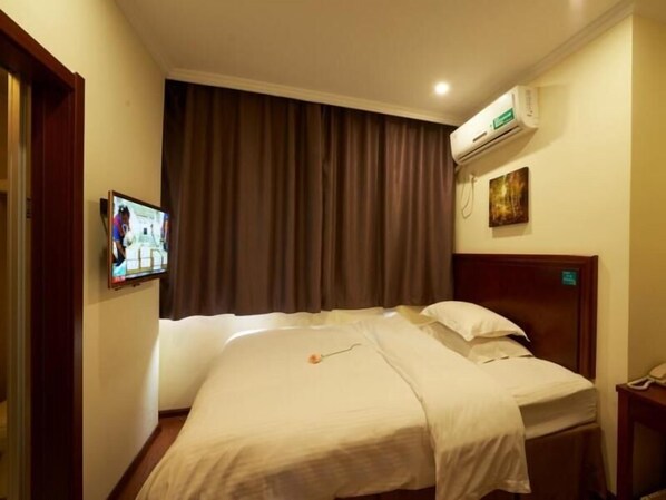 A hotel room with a bed, a TV mounted on the wall, an air conditioning unit, and a bedside table with a phone. - Greentree Inn Suzhou Park Donghuan Road Shell Hote (Suzhou)