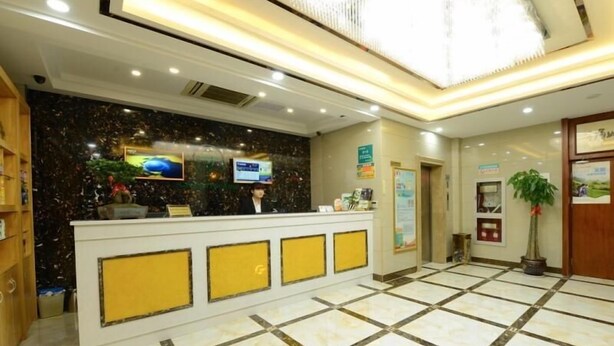 A hotel reception area with a marble floor, a reception desk, a television, and a potted plant. - Greentree Inn Suzhou Park Donghuan Road Shell Hote (Suzhou)