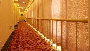 A hotel corridor with patterned carpet, a railing, and patterned curtains. - Greentree Inn Suzhou Park Donghuan Road Shell Hote (Suzhou)