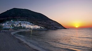 A coastal town at sunset with buildings on a hillside. - Fodele Beach Water Park Resort (Malevizi)