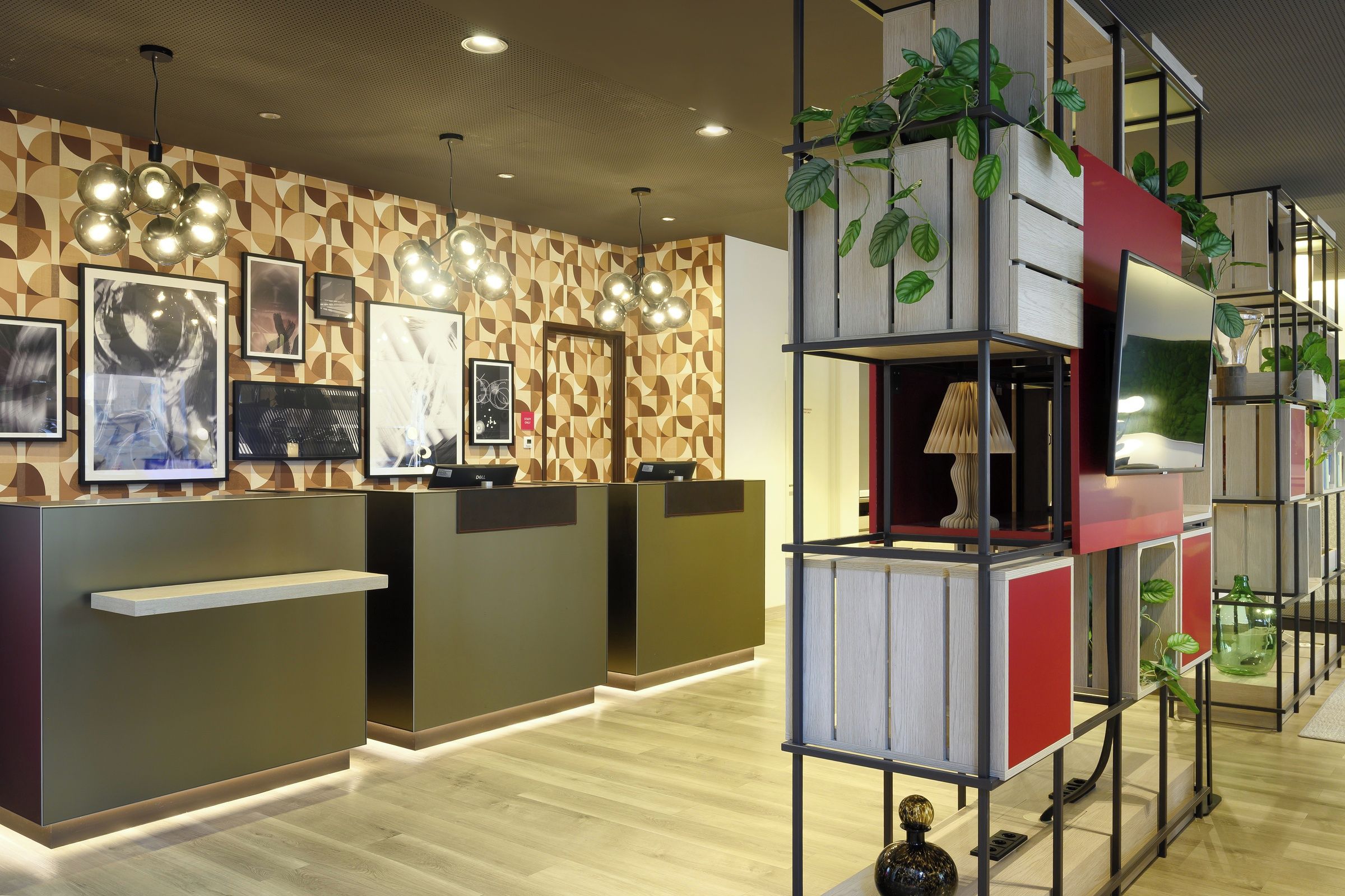 Un área de recepción con un muro de madera con diseño, obras de arte enmarcadas y un escritorio moderno con un ordenador.