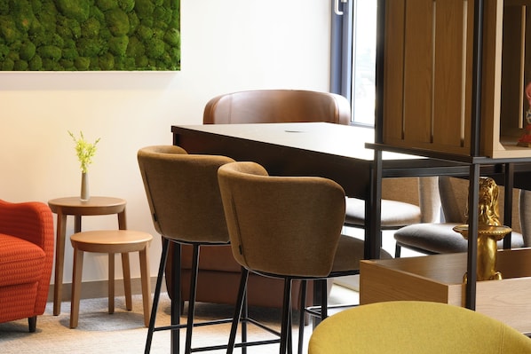 Un interno moderno con zona pranzo, due sedie, un tavolino e una pianta decorativa.