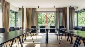 A conference room with a long table, chairs, and large windows with curtains. - Harry's Home Berlin - Moabit Hotel & Apartments (Berlin)